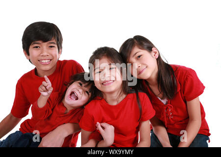 Vier Geschwister mit roten Hemden isoliert auf weißem Stockfoto