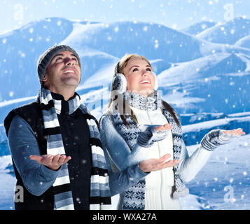 Glückliches Paar spielen im Winter Berge outdoor, aktive Menschen über natürliche Blue Winter Landschaft Hintergrund mit fallenden Schnee, Weihnachten vacatio Stockfoto