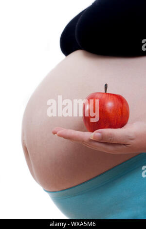 Schwangere Frau mit einem Apfel in der Hand auf weissen Hintergrund, Konzept Stockfoto