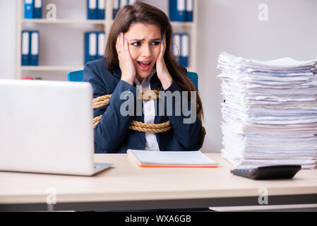 Junge schöne Mitarbeiter gebunden mit Seil im Büro Stockfoto