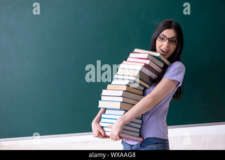 Junge weibliche Lehrer Schüler vor der grünen Platine Stockfoto