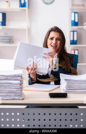 Junge schöne Mitarbeiter gebunden mit Seil im Büro Stockfoto