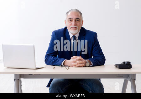 Alter Geschäftsmann Yoga Übungen im Büro Stockfoto