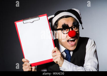 Lustiger Clown vor einem dunklen Hintergrund Stockfoto