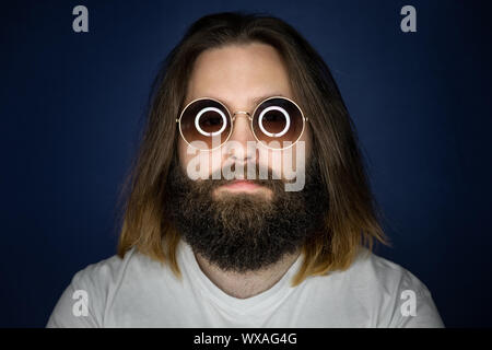 Junger Mann mit langen Haaren und Sonnenbrille bärtigen Stockfoto
