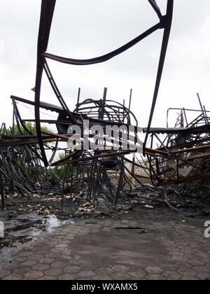 Twisted Stahlträgern nach einer Fabrik Feuer. Lager zerstört durch Feuer. Twisted Metal, Haufen von Schutt und Asche verbrannt. Stockfoto