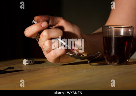 Nahaufnahme des Weibes Handzeichnung schwarzer Teer Heroin in einer Nadel Stockfoto