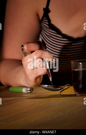 Nahaufnahme des Weibes Handzeichnung schwarzer Teer Heroin in einer Nadel Stockfoto