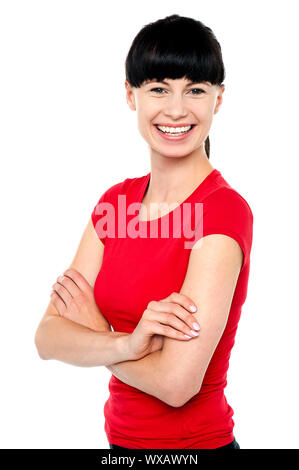 Lässige Schuss wunderschönen jungen Frau fällt eine Pose mit verschränkten Armen. Stockfoto