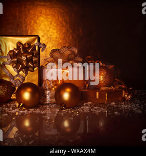 Bild der Goldenen Geschenkboxen auf dunklen grunge Hintergrund, Vielzahl von präsentiert mit Weihnachtsbaum Spielzeug eingerichtet, studio Shot, Frohes Neues Jahr Gruß c Stockfoto