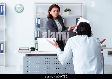 Alte Frau Boss und junge männliche Mitarbeiter im Büro Stockfoto