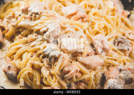 Nudeln mit Lachs und Sahnesoße auf Pfanne Stockfoto