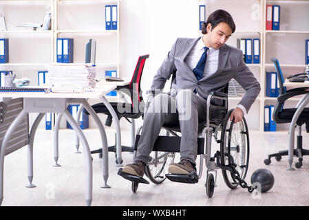 Jungen gutaussehenden Mitarbeiter im Rollstuhl die Arbeit im Büro Stockfoto