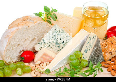 Verschiedene Arten von Käse und Beilagen auf Holzplatte Stockfoto