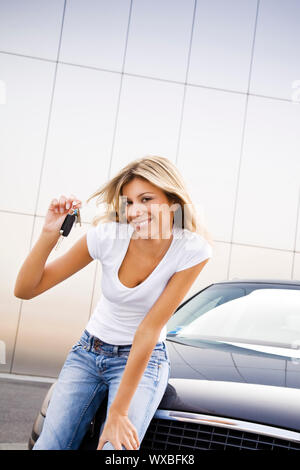 Junge Frau mit Tasten für Neuwagen Stockfoto