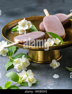 Hausgemachtes Vanilleeis mit Schokoladenglasur bestreichen. Stockfoto