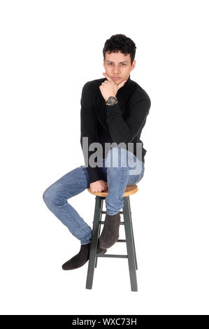 Entspannende junge Mann sitzt im Studio Stockfoto