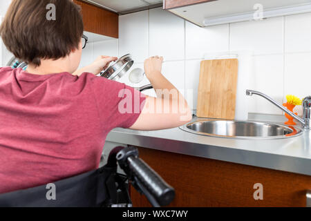 Behinderte Frau Kochen in der Küche Stockfoto