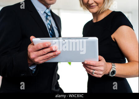 Chef und Sekretärin posiert mit einem Tablet-Gerät, Bild beschnitten. Stockfoto