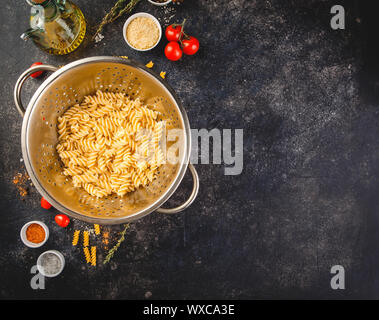 Fusilli in Edelstahl Sieb Stockfoto