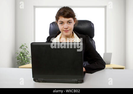 Junge weibliche Business Mitarbeiter neu eingestellt oder ein Student tun writer Praktikum. Sie ist in einer Workstation in einem Corporate Office der Texteingabe auf einem Computer. Stockfoto