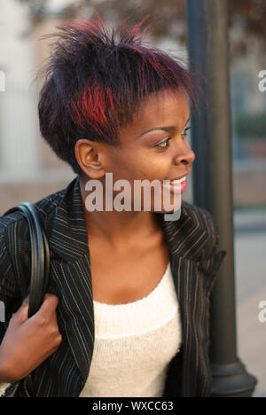 Afrikanische amerikanische Geschäftsfrau Porträt - Blick nach links während des Wartens auf ÖPNV-Haltestelle Stockfoto
