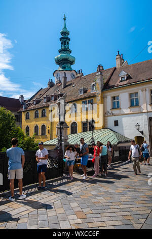 BRATISLAVA, SLOWAKEI - 18. AUGUST 2019: Statue des Hl. Johannes von Nepomuk, im Hintergrund der Michael Gate Tower Stockfoto