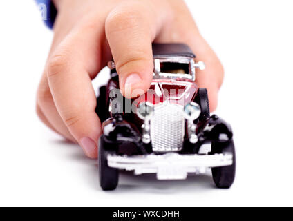 Makro Blick auf die Hand des Kindes spielen mit Spielzeug Auto auf weißem Hintergrund Stockfoto