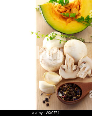 Pilze und Kabocha Kürbis mit Gewürzen und Kräutern auf Schneidebrett Stockfoto