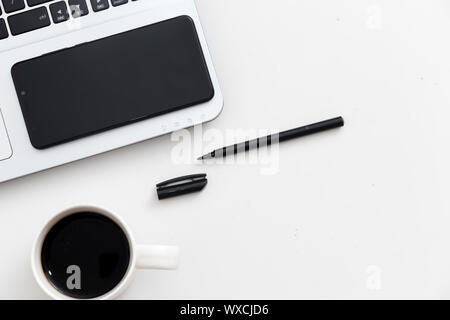 Weiß Schreibtisch mit Laptop Handy Kaffee und Stift Stockfoto