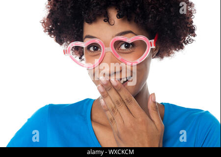 Bild von einer jungen Frau mit herzförmigen Rahmen ihr Kichern zu ersticken beschnitten Stockfoto