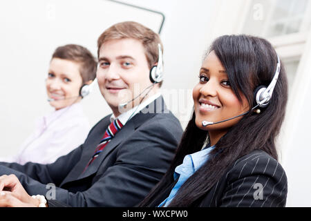 lächelnde Callcenter-Agent mit Kopfhörer-Unterstützung Stockfoto