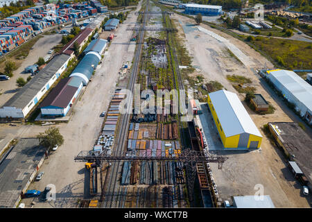 Ansicht von oben in die industrielle Zone: Eisenbahnschienen, Garagen, Lagerhallen, Container zur Lagerung von Waren. Das Konzept der Lagerung der Waren Importeure, Expor Stockfoto