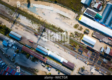 Ansicht von oben in die industrielle Zone: Eisenbahnschienen, Garagen, Lagerhallen, Container zur Lagerung von Waren. Das Konzept der Lagerung der Waren Importeure, Expor Stockfoto