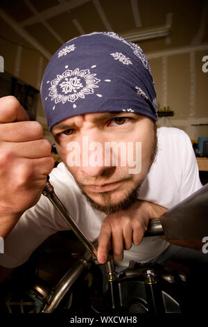 Hispanische Mechaniker arbeitet an einem Chopper-Stil-Motorrad Stockfoto