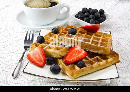 Frisch gebackene Waffeln mit Beeren und Kaffee Stockfoto