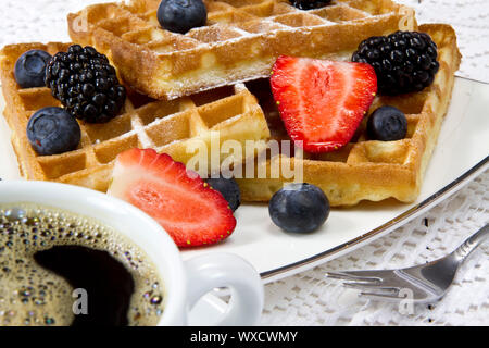 Frisch gebackene Waffeln mit Beeren und Kaffee Stockfoto
