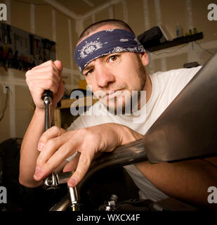 Hispanische Mechaniker arbeitet an einem Chopper-Stil-Motorrad Stockfoto