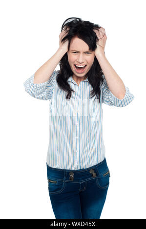 Frustrierte junge Frau hält ihren Kopf und schreien laut. Stockfoto