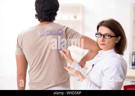 Gemeinsame Flexibilität des Weiblichen Arzt Patient mit Winkelmesser überprüfen Stockfoto