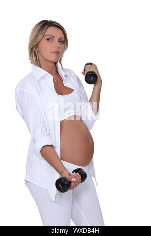 Schwangere Frau mit handweights Stockfoto