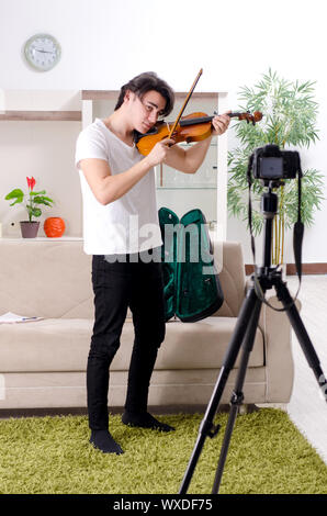 Junge männliche blogger Violine zu Hause spielen Stockfoto