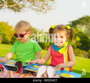 Foto von kids Buch lesen im Freien in der Kindertagesstätte, zwei glückliche Kinder, Märchen, Bruder und Schwester studieren Lektion, Vorschule, beste Frie Stockfoto