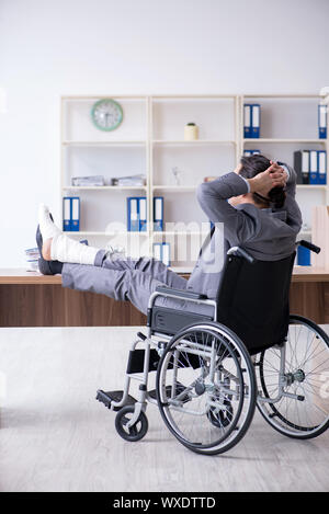 Männliche Angestellte im Rollstuhl im Büro Stockfoto