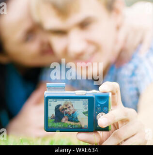Junge emotionale Happy teenage Paar unter Bild auf Gras im City Park Stockfoto