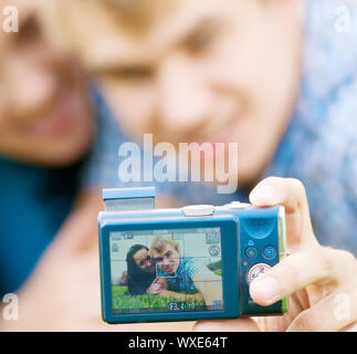 Junge emotionale Happy teenage Paar unter Bild auf Gras im City Park Stockfoto