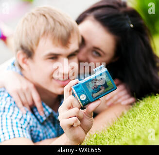 Junge emotionale Happy teenage Paar unter Bild auf Gras im City Park Stockfoto