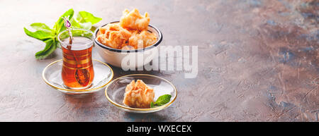 Traditionelle türkische arabische Dessert und einem Glas Tee mit Minze Stockfoto