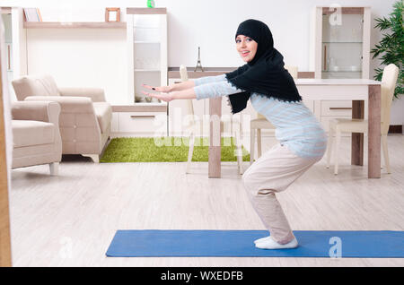 Junge Frau im hijab Übungen zu Hause Stockfoto
