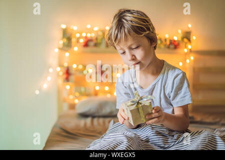 Little Boy öffnet sich ein Geschenk aus dem Adventskalender. Winter saison Tradition. Weihnachten Adventskalender Stockfoto